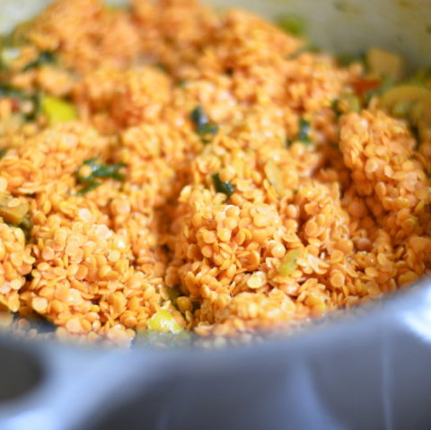 coral red lentils added to soup vegetables